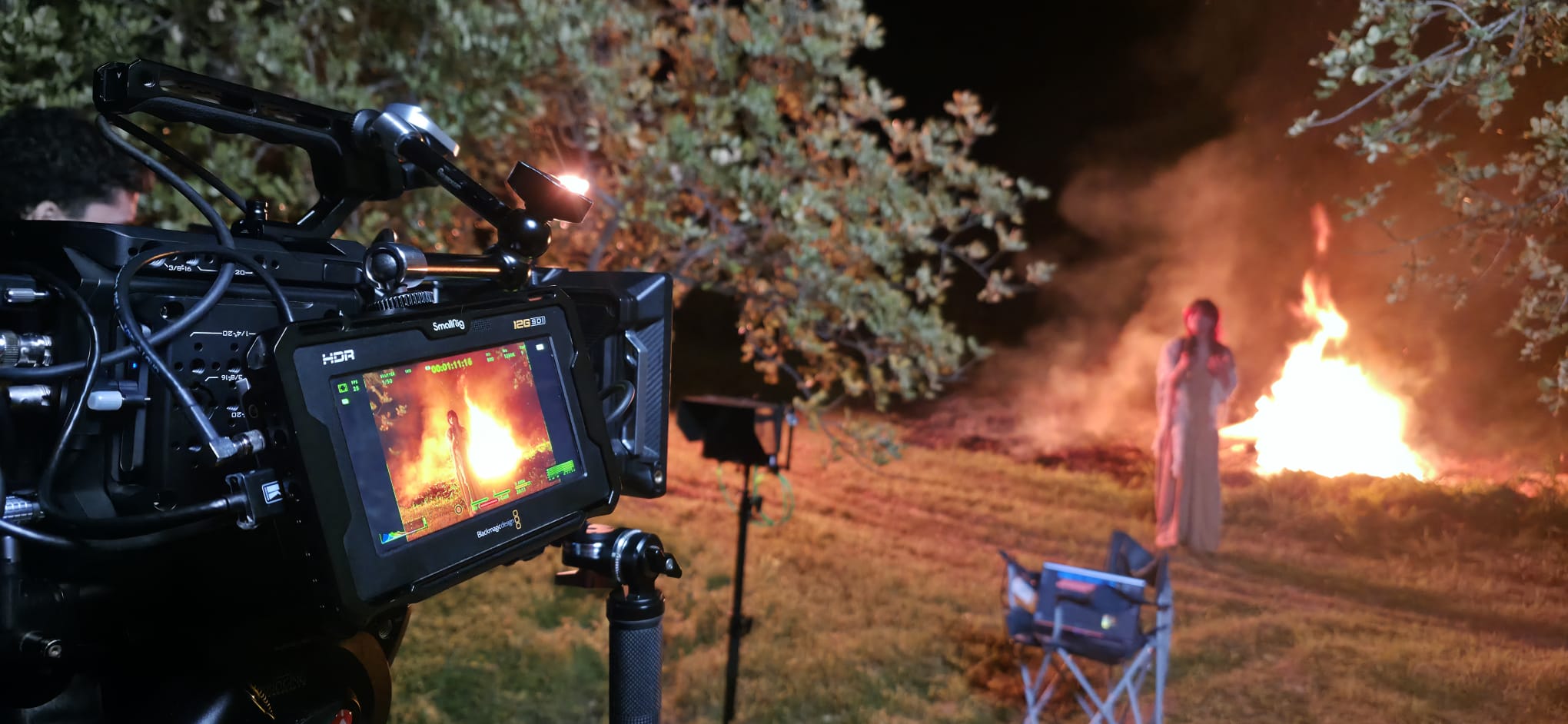 Film crew operating a camera on set with warm backlight